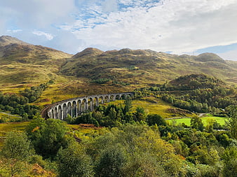 Glenfinnan Viaduct in the Scottish Highlands with rolling green hills
