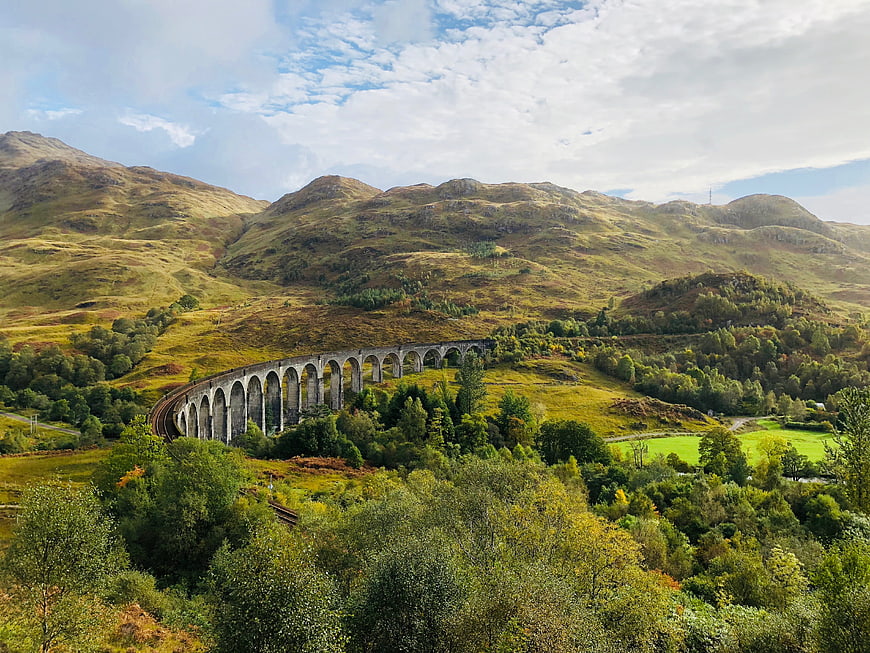 Glenfinnan Viaduct in the Scottish Highlands with rolling green hills