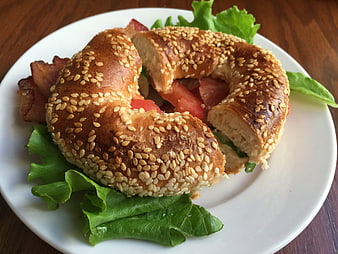 Sesame Bagel Sandwich with Bacon, Tomato, and Lettuce on White Plate