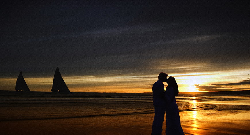 Silhouette of Romantic Couple Kissing on Beach at Sunset