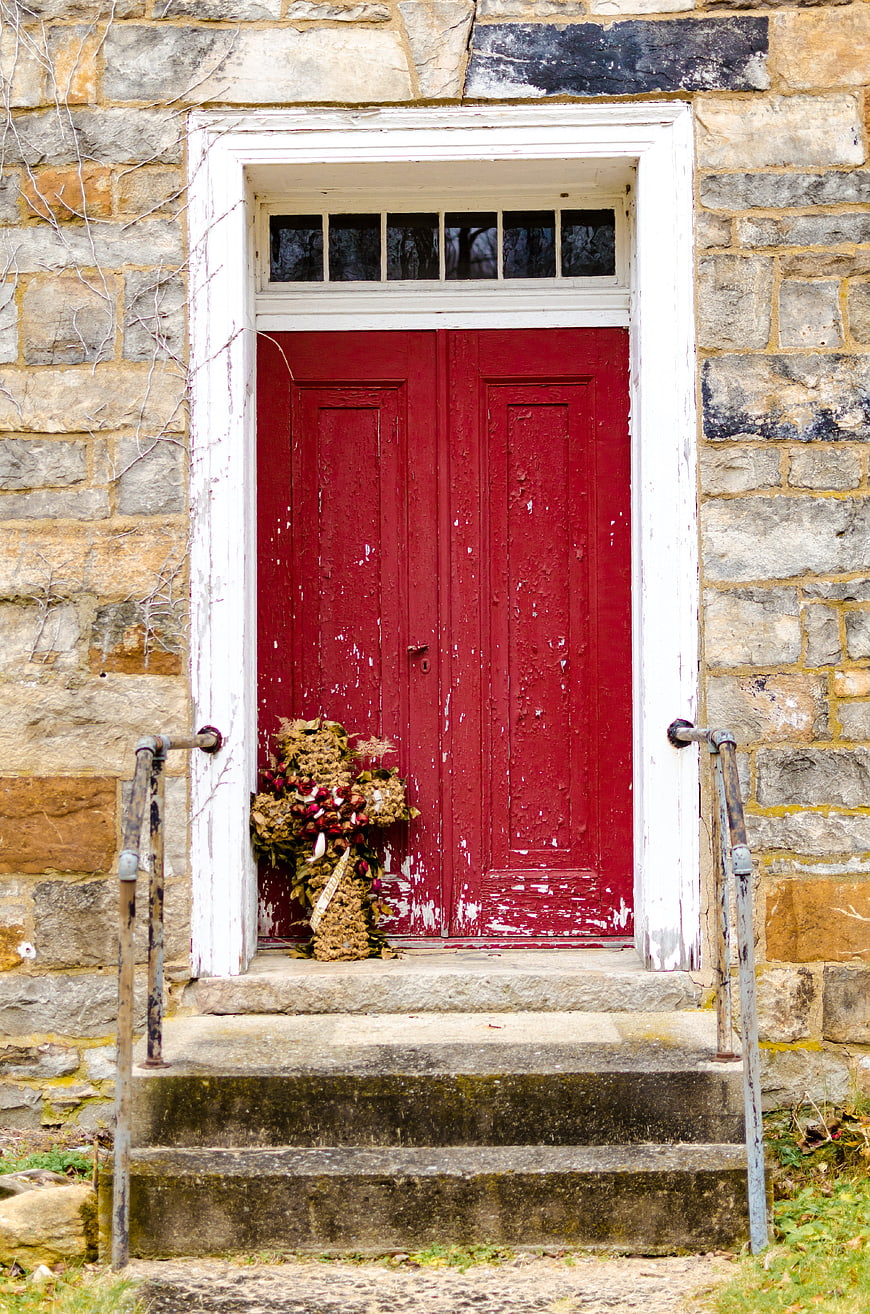 Vintage Red Wooden Door on Old Stone Building