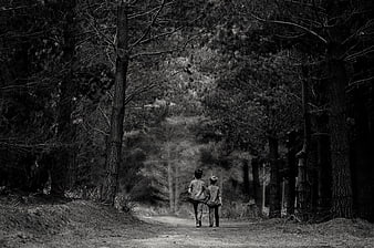 Two Boys Walking Away on a Forest Path in Black and White