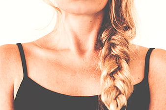 Close-up of woman with blonde braid and black tank top