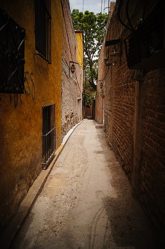 Narrow cobblestone alleyway in old colonial Mexican town