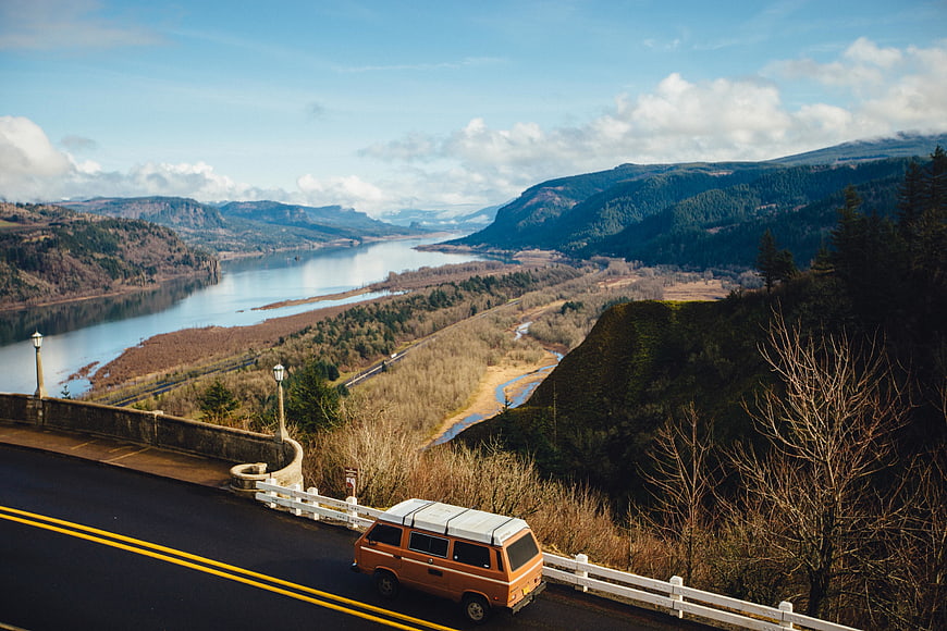 Orange vintage van parked on scenic mountain overlook road