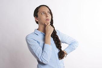 Pensive Woman in Blue Shirt Thinking with Hand on Chin