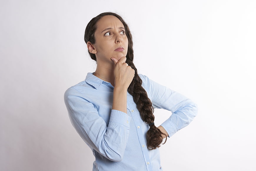 Pensive Woman in Blue Shirt Thinking with Hand on Chin