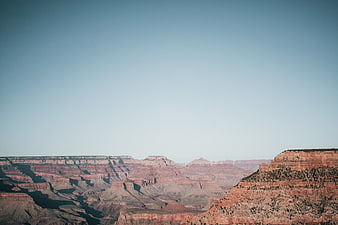 Vast Grand Canyon Landscape with Red Rock Formations and Blue Sky