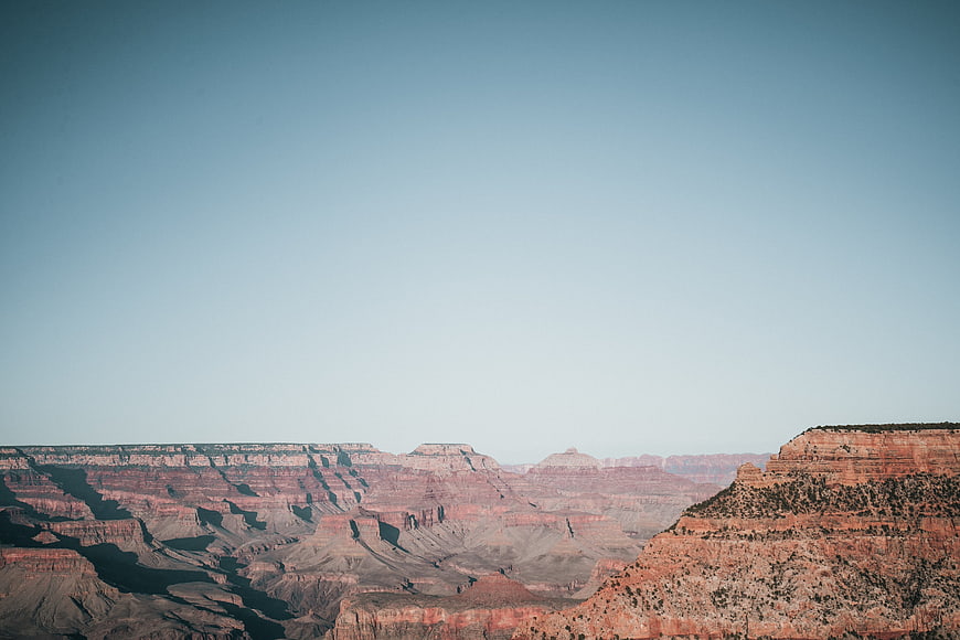 Vast Grand Canyon Landscape with Red Rock Formations and Blue Sky