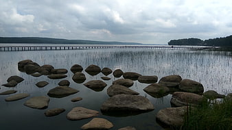Serene Lake Landscape with Stepping Stones and Long Pier