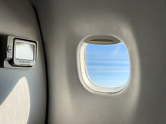 Airplane Window View of Blue Sky and Clouds