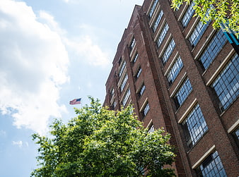 Low angle view of red brick office building with American flag