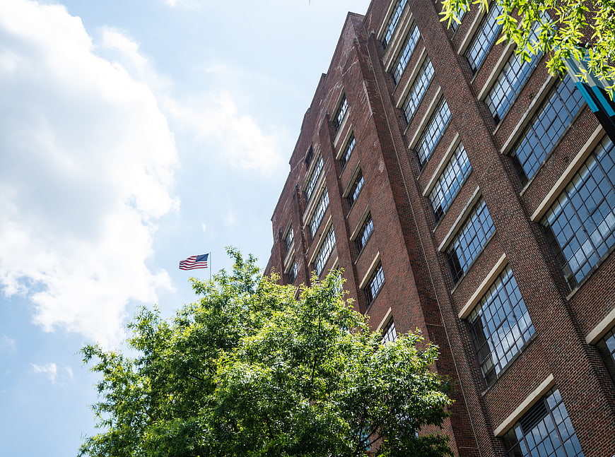 Low angle view of red brick office building with American flag
