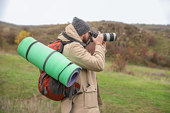 Male Hiker With Backpack And Telephoto Camera In Autumn Landscape