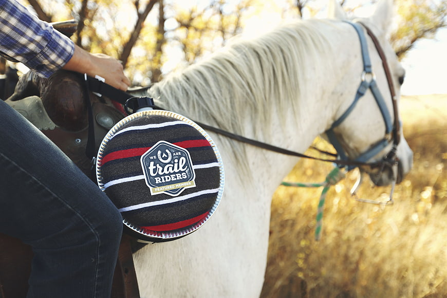 Trail Riders saddle pad on white horse in field