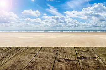 Wooden Deck Overlooking Sandy Beach and Blue Sky