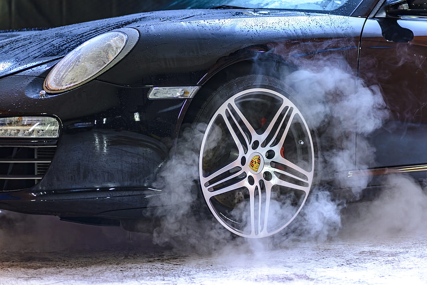 Black Porsche Wheel Spinning with Steam in Car Wash
