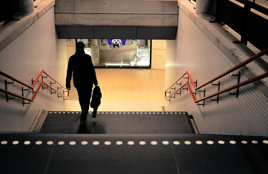 Man Walking Down Subway Stairs at Night