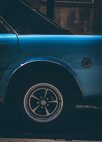 Close-up of vintage blue car wheel and fender