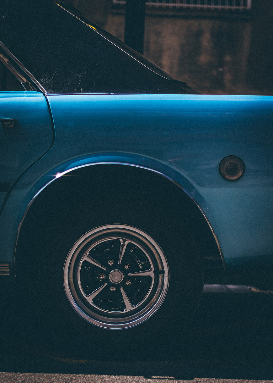 Close-up of vintage blue car wheel and fender