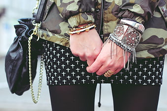 Fashion Detail: Silver and Gold Jewelry on Camouflage Jacket and Cross Skirt