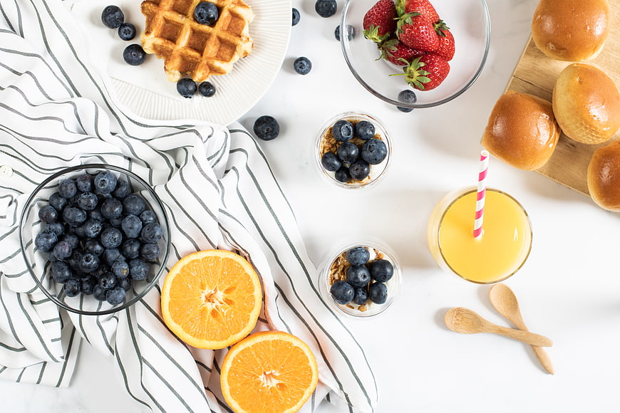 Healthy breakfast flat lay with waffles, berries, and orange juice