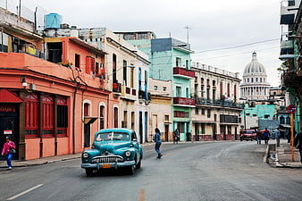 Vintage turquoise classic car driving on Havana street with Capitolio