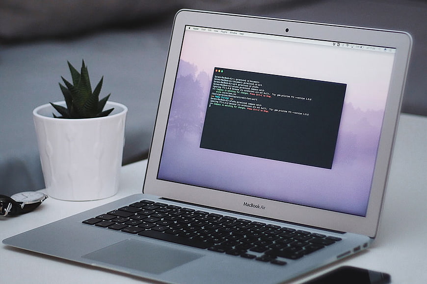 MacBook Air with Terminal Code on Desk