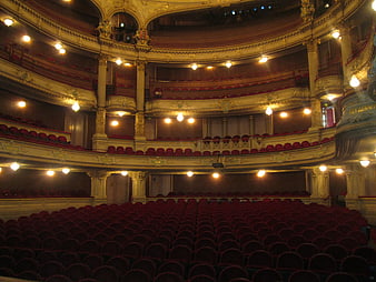 Interior of an ornate historic theater with red seats and gold balconies