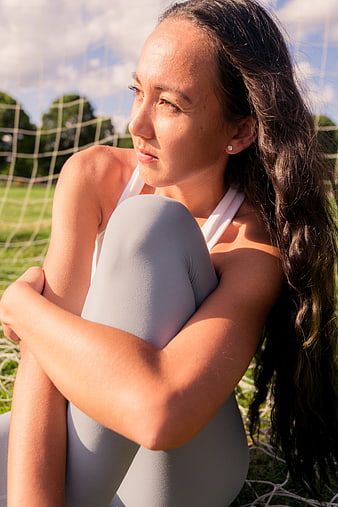 Young female athlete resting on soccer field