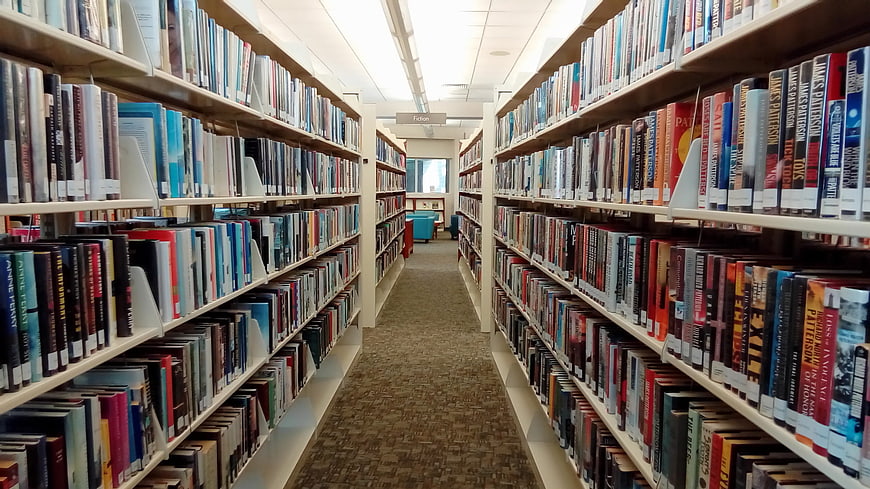 Library aisle with bookshelves and fiction section