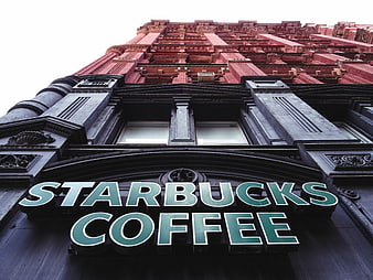 Low Angle View of Starbucks Coffee Sign on Historic Red Brick Building