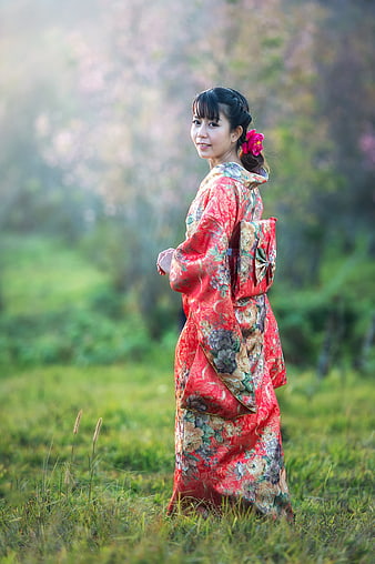 Woman in Red Floral Kimono Standing in Misty Cherry Blossom Garden
