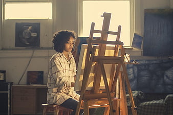 Young Woman Artist Painting in Sunlit Studio