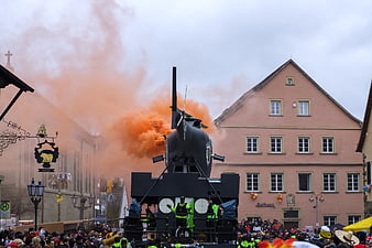 Carnival parade float with helicopter and orange smoke