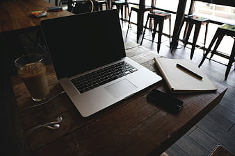 Laptop Workspace with Coffee and Notebook on Wooden Table