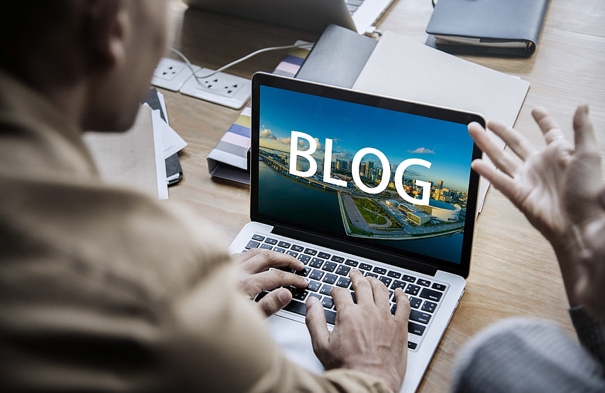 Man Typing On Laptop With Blog Text Displayed On Screen