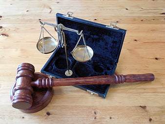 Wooden Gavel and Brass Scales of Justice on Wooden Table