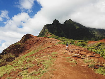 Hikers on Red Dirt Trail with Green Mountain Peaks