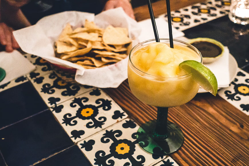 Frozen Margarita with Lime and Tortilla Chips on Table