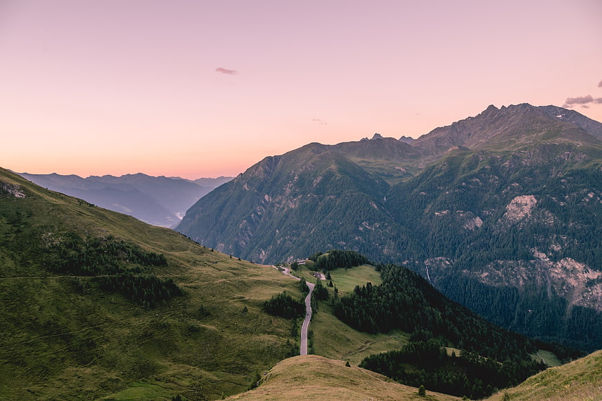 Winding Mountain Road Through Green Highland Valley at Sunset