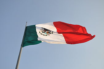 Mexican flag waving against a clear blue sky