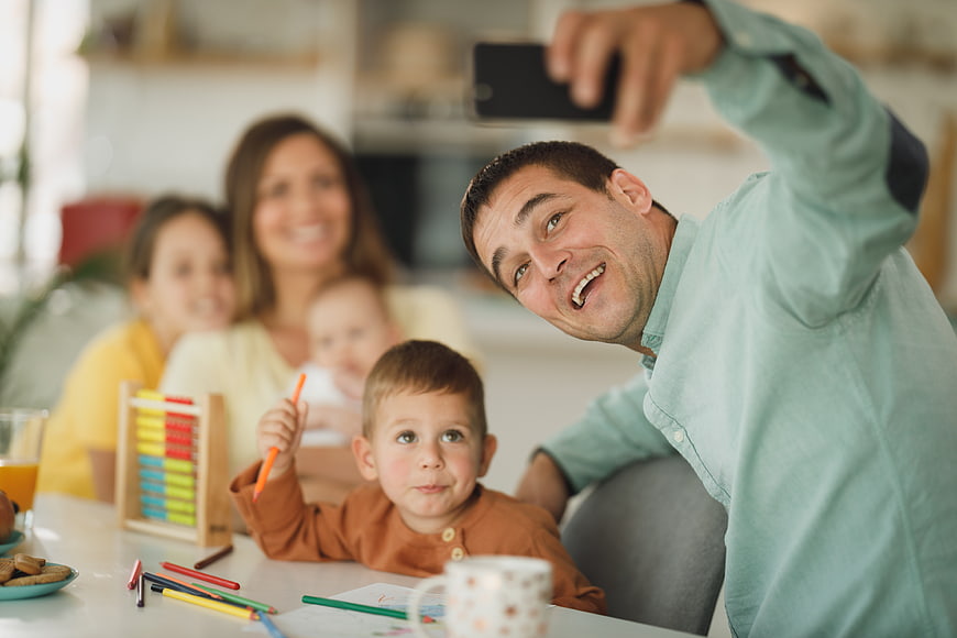 Happy family taking selfie at home with children