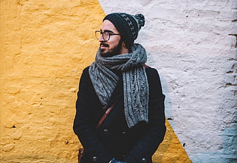 Man in Winter Scarf and Beanie Against Yellow Wall