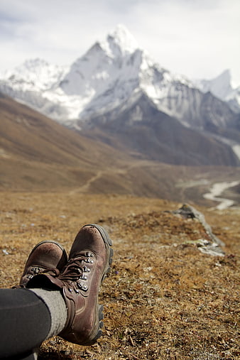 Hiker boots resting with snowy mountain peak background