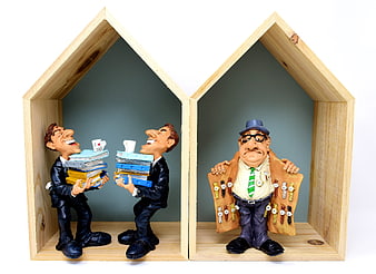 Conceptual clay figurines illustrating tax evasion and bureaucracy in wooden house frames