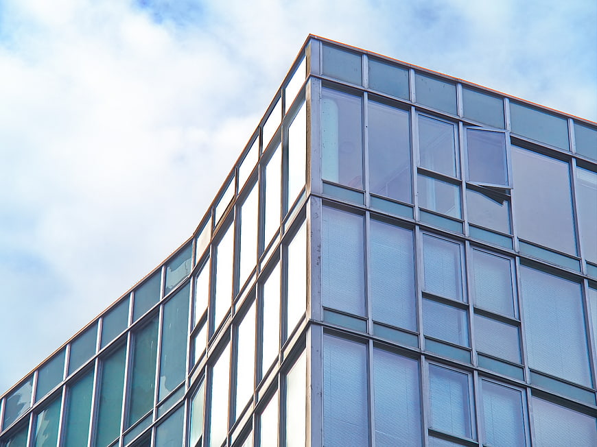 Modern Glass Office Building Facade Against Blue Sky