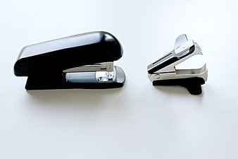Black and Silver Staplers on White Background