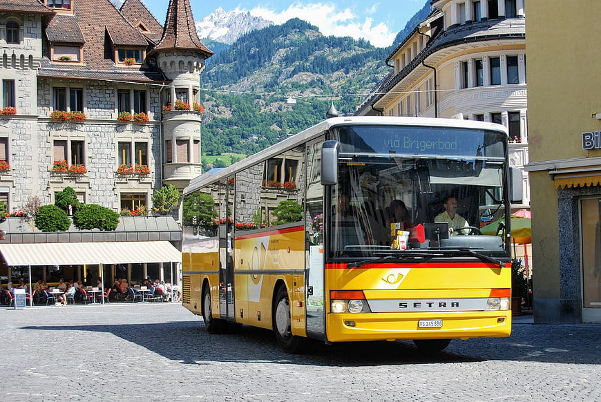 Yellow Setra bus in Swiss mountain town square