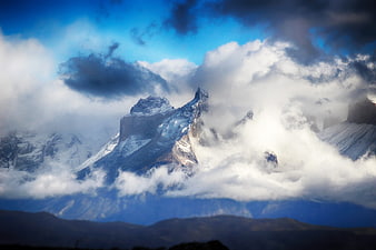 Dramatic Snowy Mountain Peak Emerging from Clouds